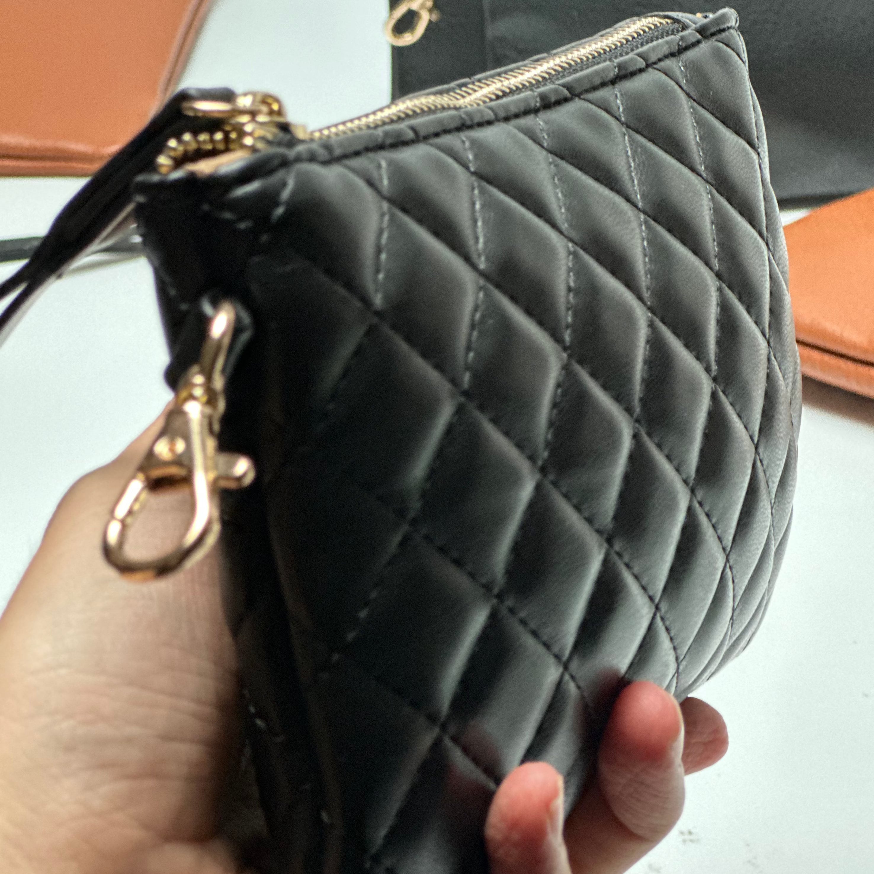 Quilted clip-on mini bag for moms held in hand with its gold clip