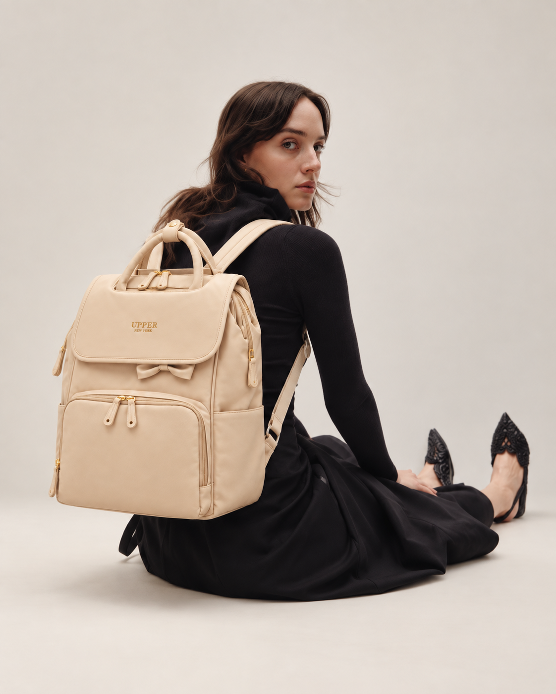 Commuter 23 everyday backpack worn by a mom seated on the floor, side view