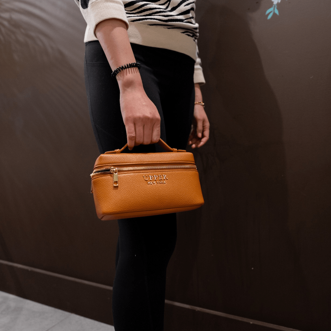 Madison mini bag in caramel carried by its handle by a mom