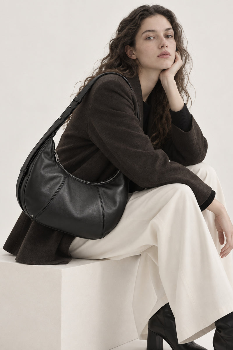 Parent seated wearing the Rivage crossbody