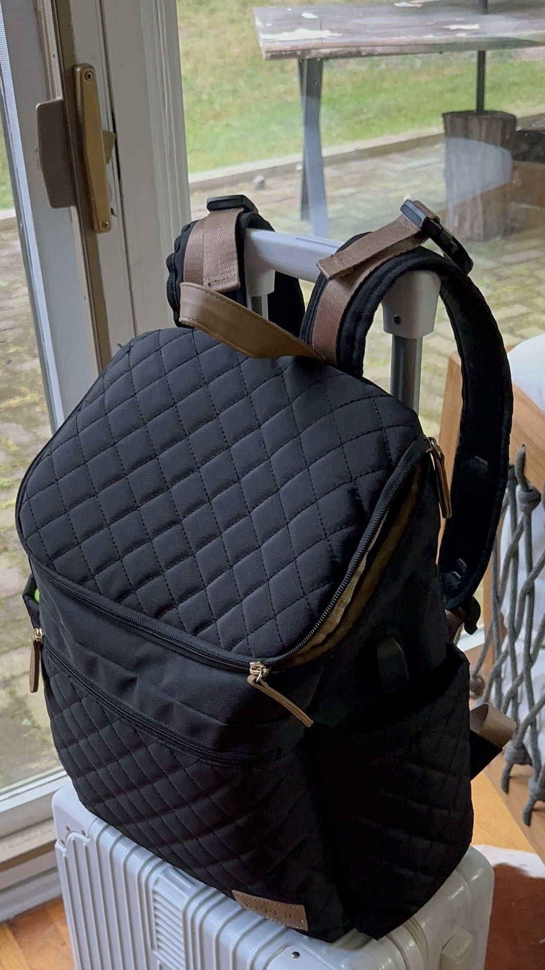 Maison Air backpack sitting on a carry-on