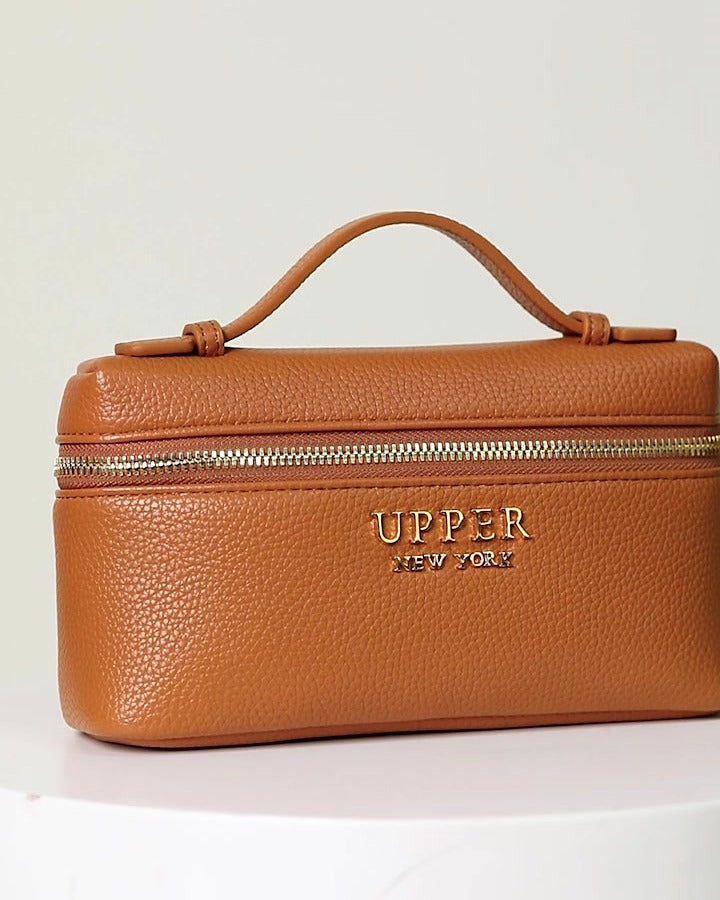 Mini crossbody bag in caramel with gold zip and top handle, front view