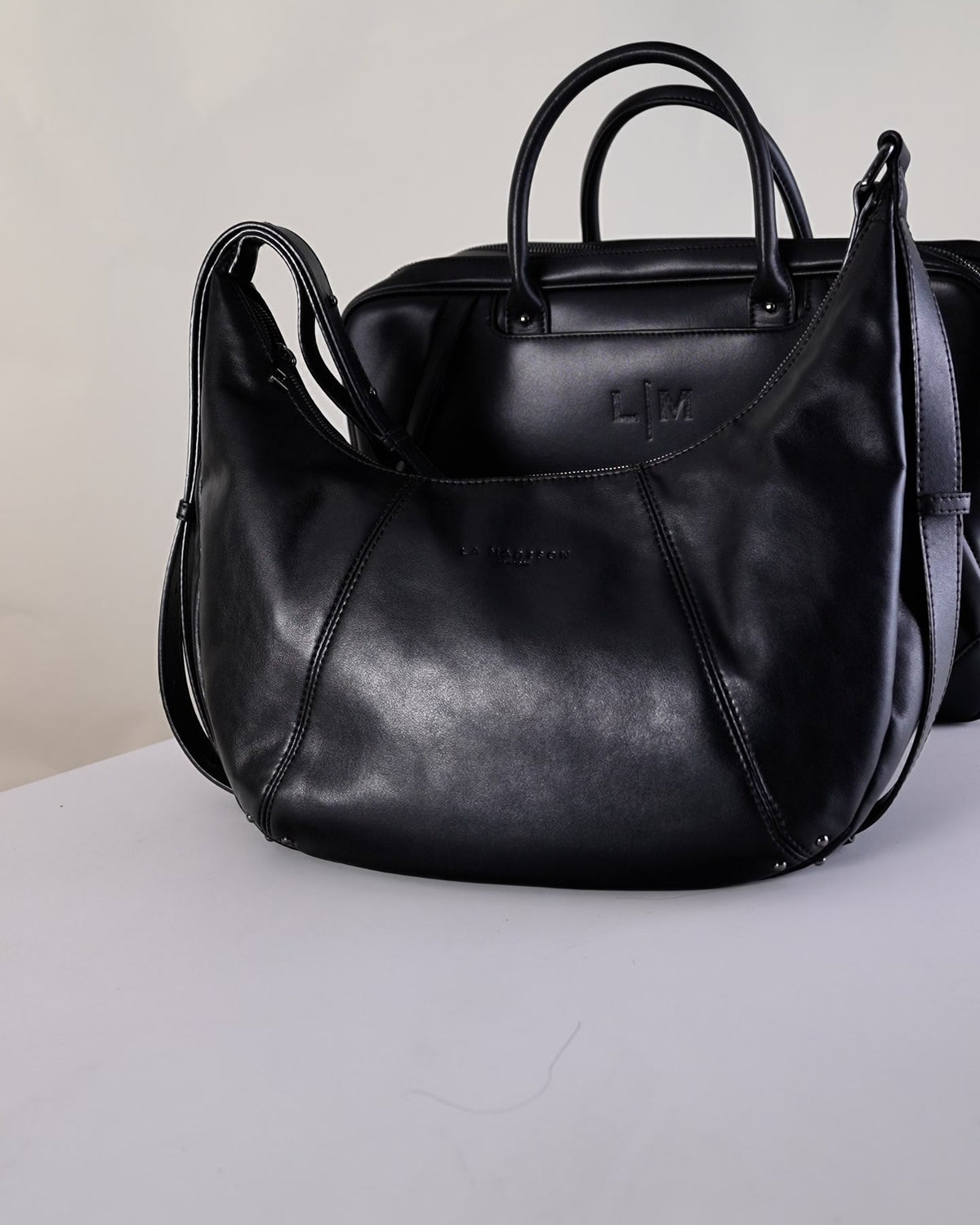 Weekender travel bag in black with its handles up, ready to pack, for parents on trips